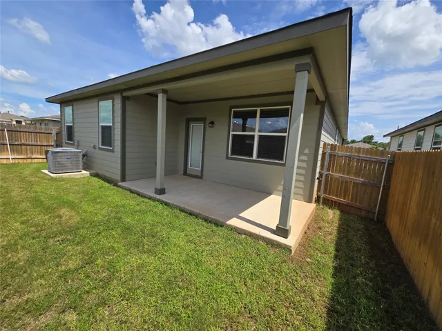 a view of house with backyard porch and wooden fence