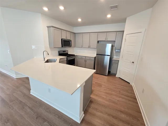 a kitchen with stainless steel appliances a refrigerator stove microwave and cabinets