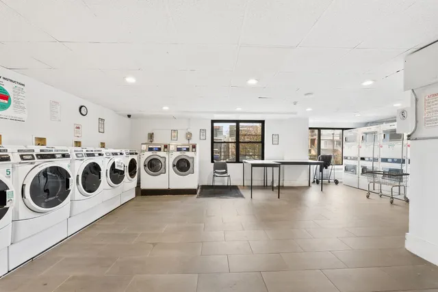 a view of kitchen with stainless steel appliances granite countertop a stove and a sink with cabinets