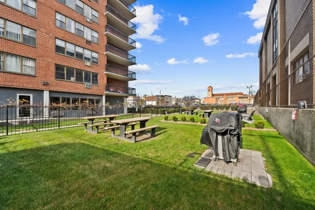 a view of a swimming pool with a bench and trees in the background
