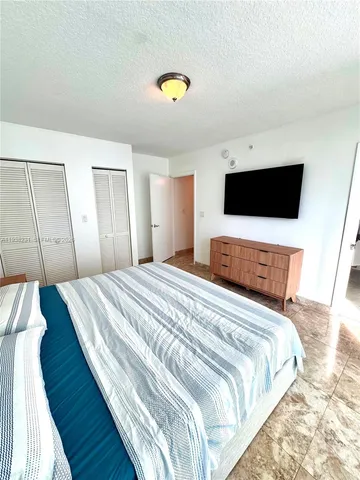a bedroom with a bed and a flat screen tv