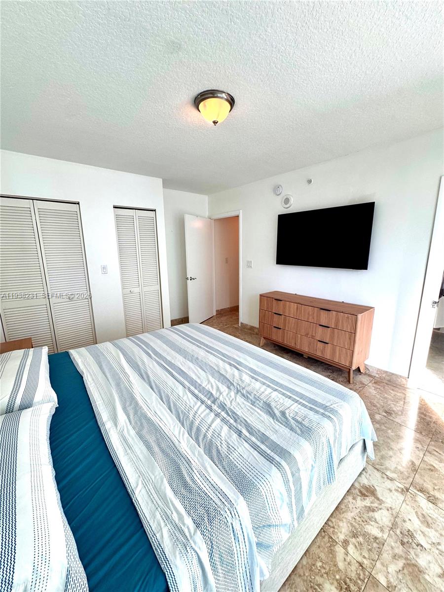 31 Southeast 5th Street, Unit 2710 Miami, FL 33131 - Photo 6 of 25 a bedroom with a bed and a flat screen tv