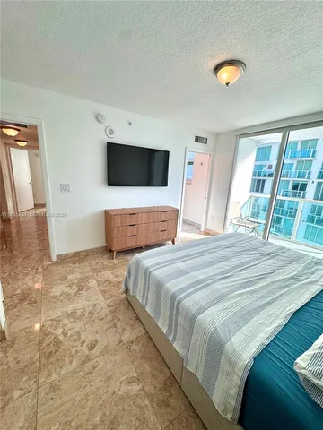 a bedroom with a large bed and a flat screen tv