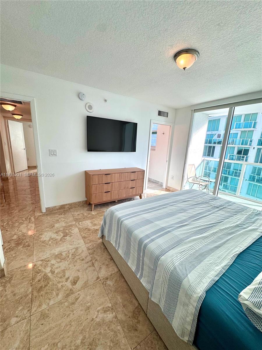 31 Southeast 5th Street, Unit 2710 Miami, FL 33131 - Photo 7 of 25 a bedroom with a large bed and a flat screen tv