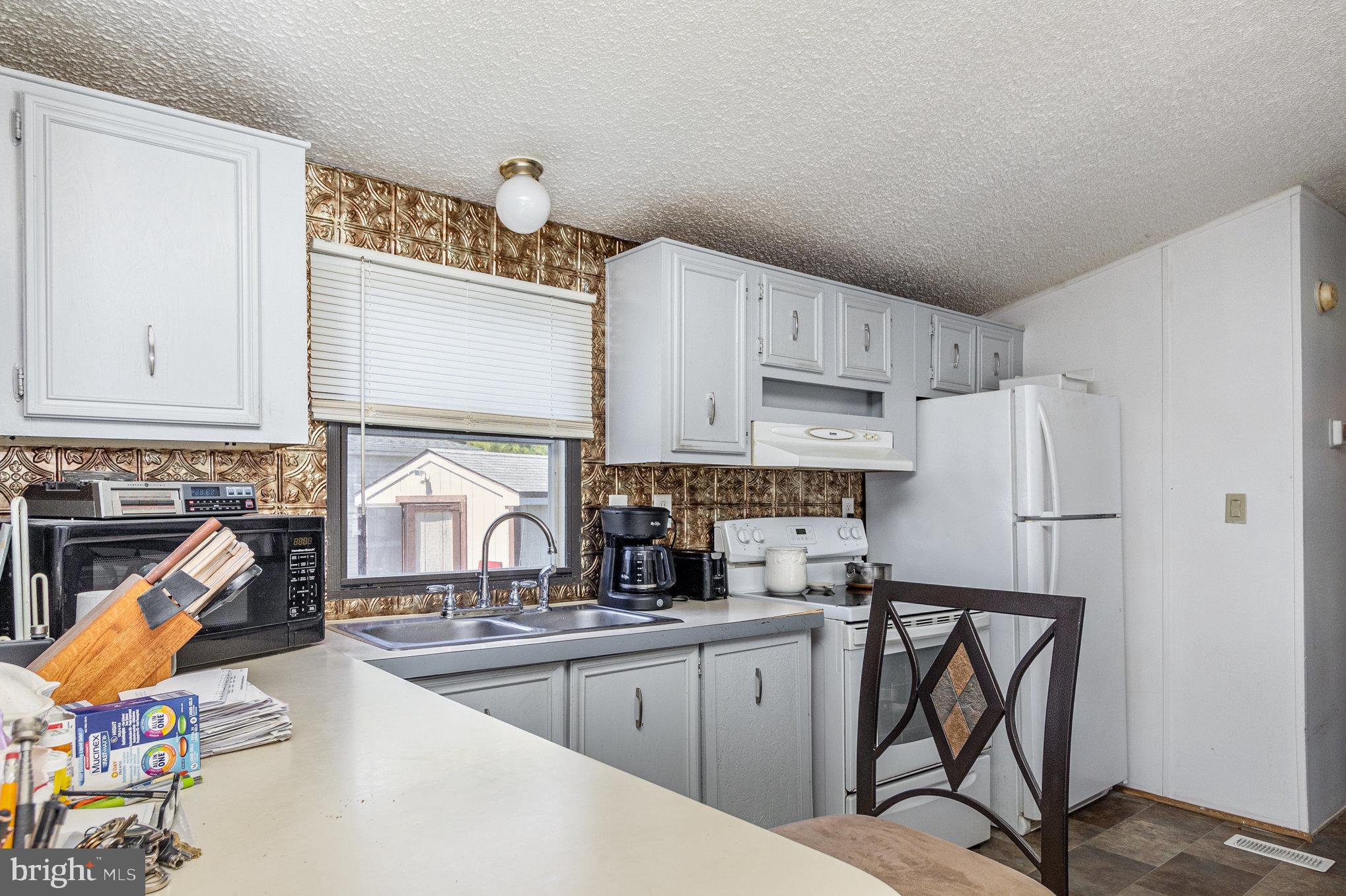 63 Peppermint Lane Middle River, MD 21220 - Photo 6 of 24 a kitchen with stainless steel appliances granite countertop a sink refrigerator and cabinets