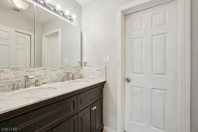 a bathroom with a double vanity sink and a mirror