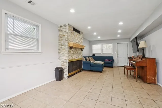 a living room with furniture a computer on desk and chair