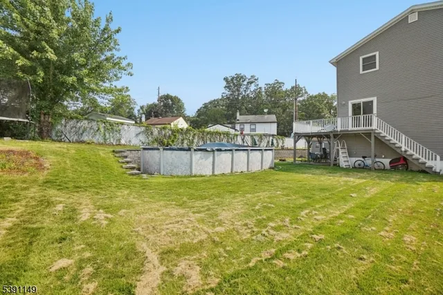 a view of a house with a yard and a large tree
