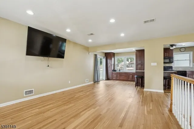 a view of a livingroom with wooden floor and a flat screen tv