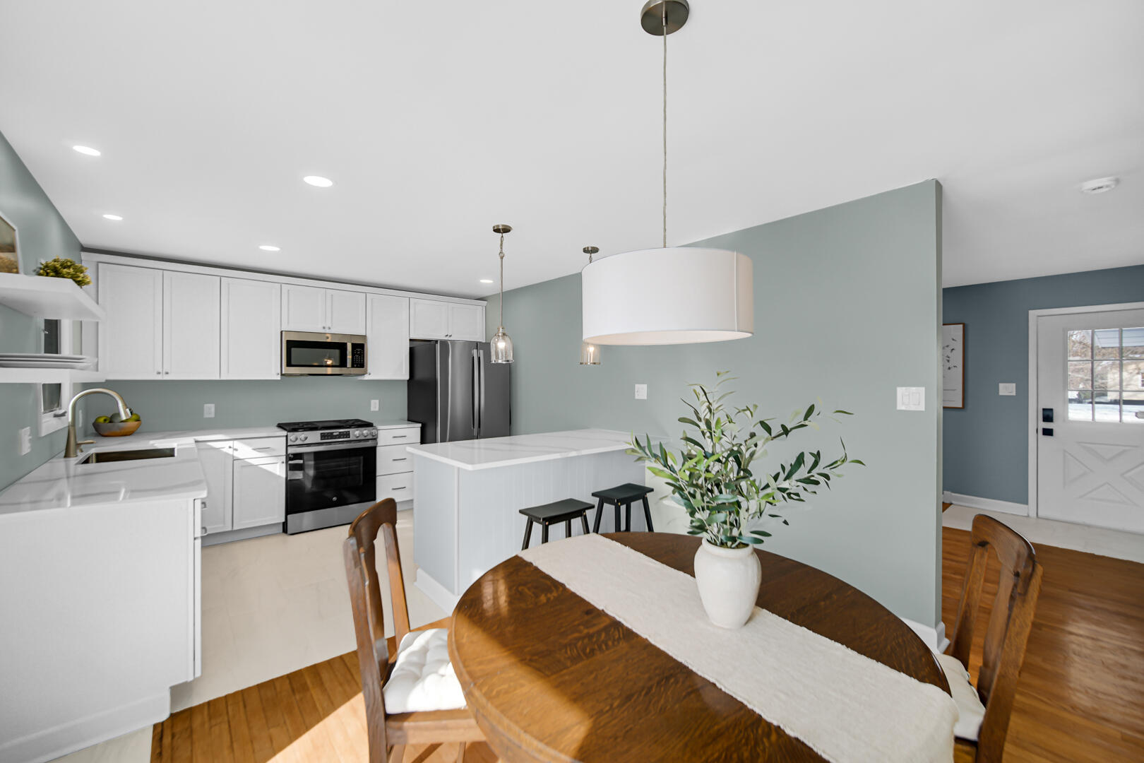1515 West 94th Avenue Crown Point, IN 46307 - Photo 11 of 23 a kitchen with stainless steel appliances a dining table chairs in it and white cabinets