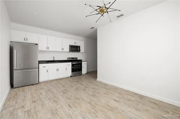 a kitchen with stainless steel appliances a refrigerator sink and cabinets