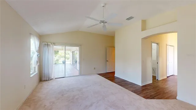 a view of a big room with windows and chandelier fan