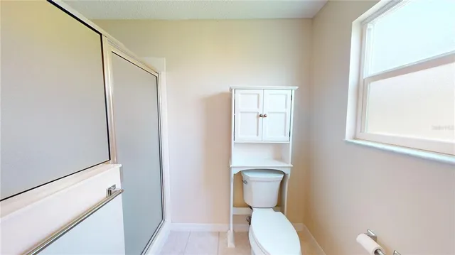 a white toilet sitting next to a bathroom sink and a window