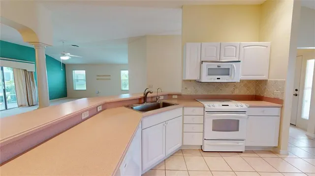 a kitchen with white cabinets appliances and a sink