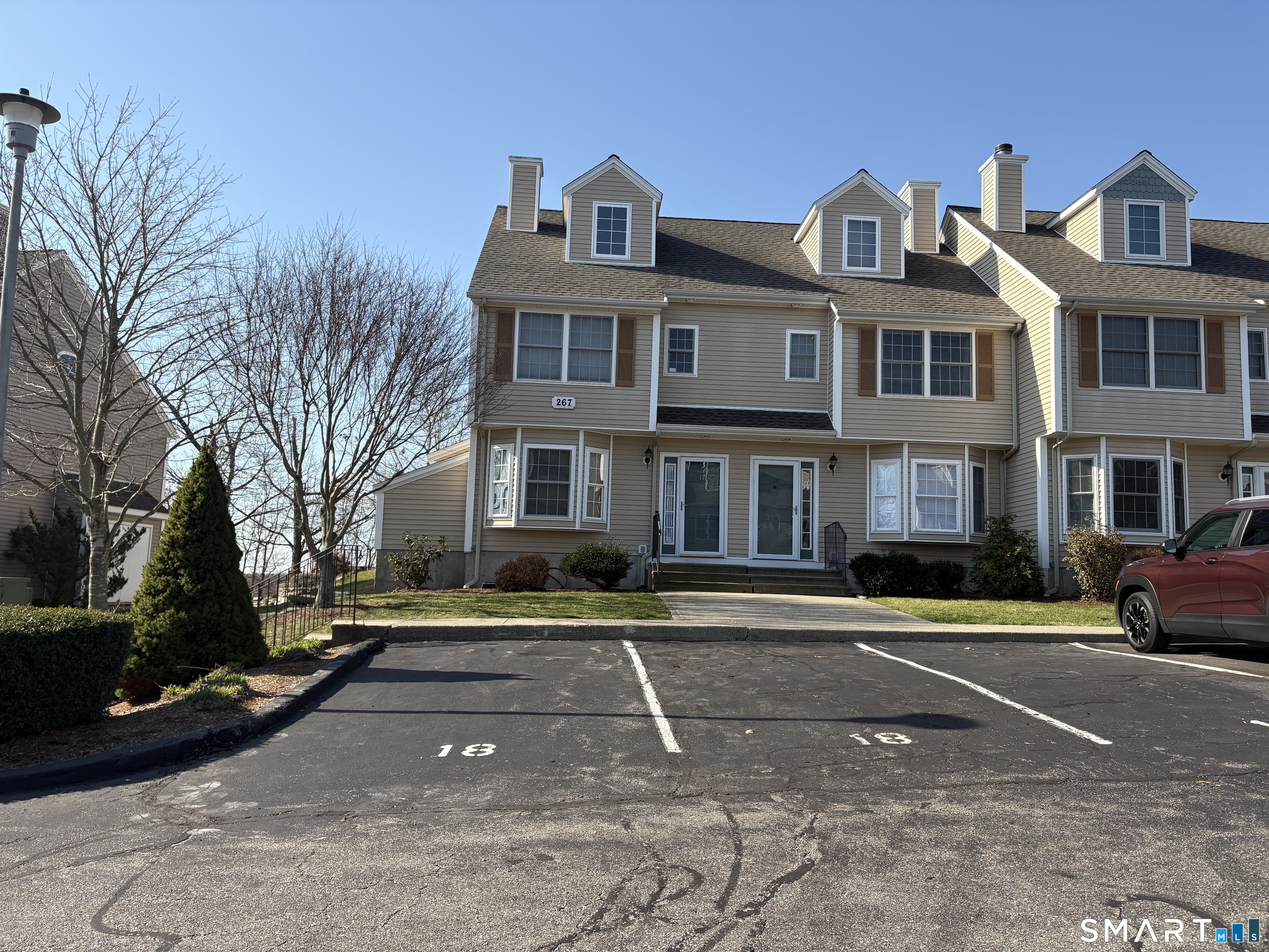 267 Bridge Street, Unit 18 Groton, CT 06340 - Photo 2 of 16 a front view of a residential apartment building with a yard