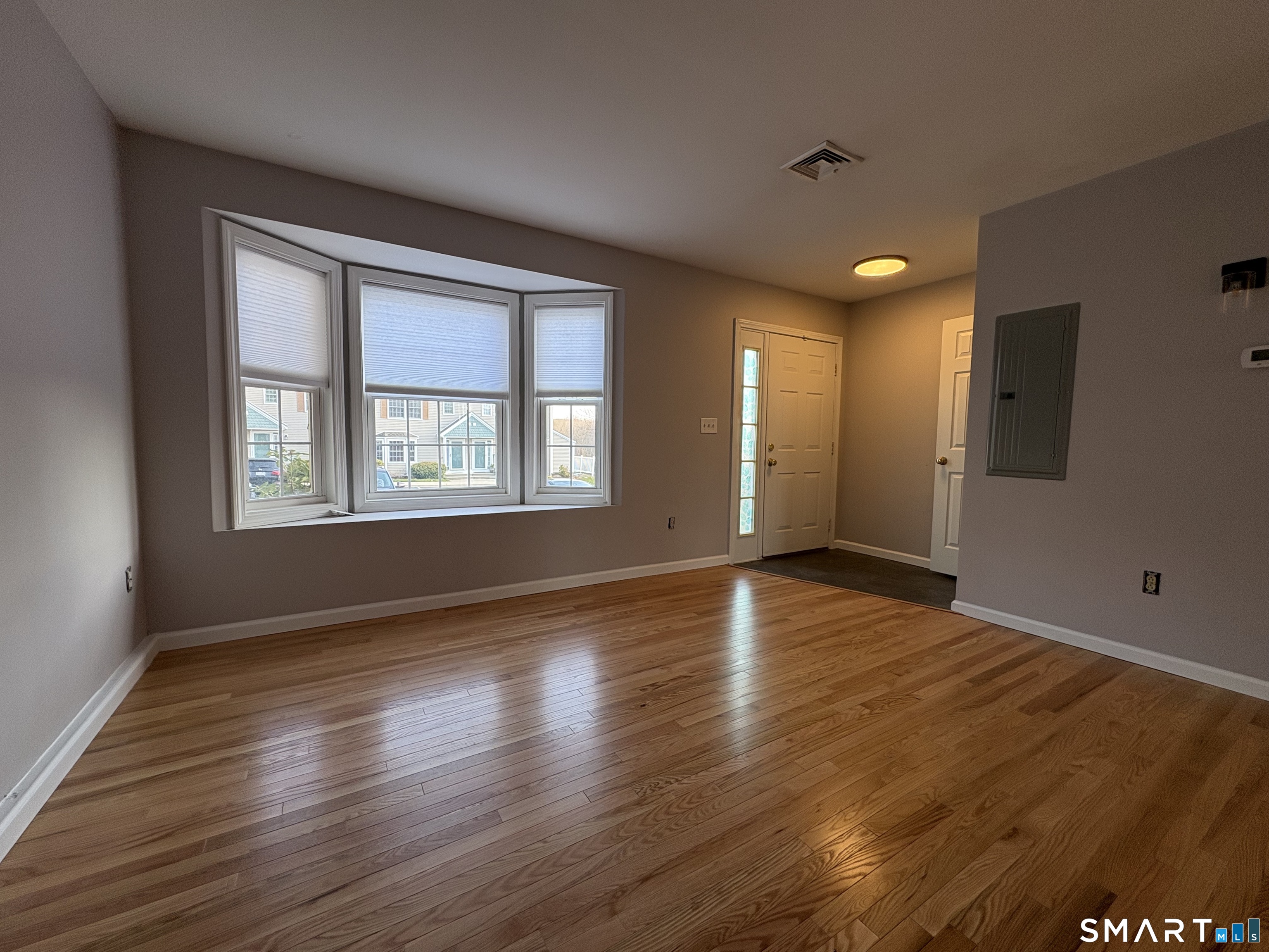 267 Bridge Street, Unit 18 Groton, CT 06340 - Photo 3 of 16 a view of an empty room with wooden floor and a window