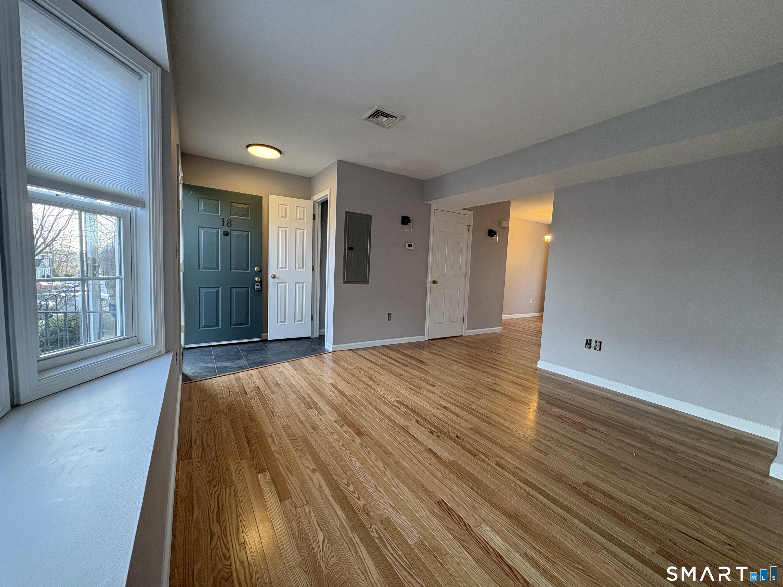 267 Bridge Street, Unit 18 Groton, CT 06340 - Photo 5 of 16 a view of a room with wooden floor and brick walls