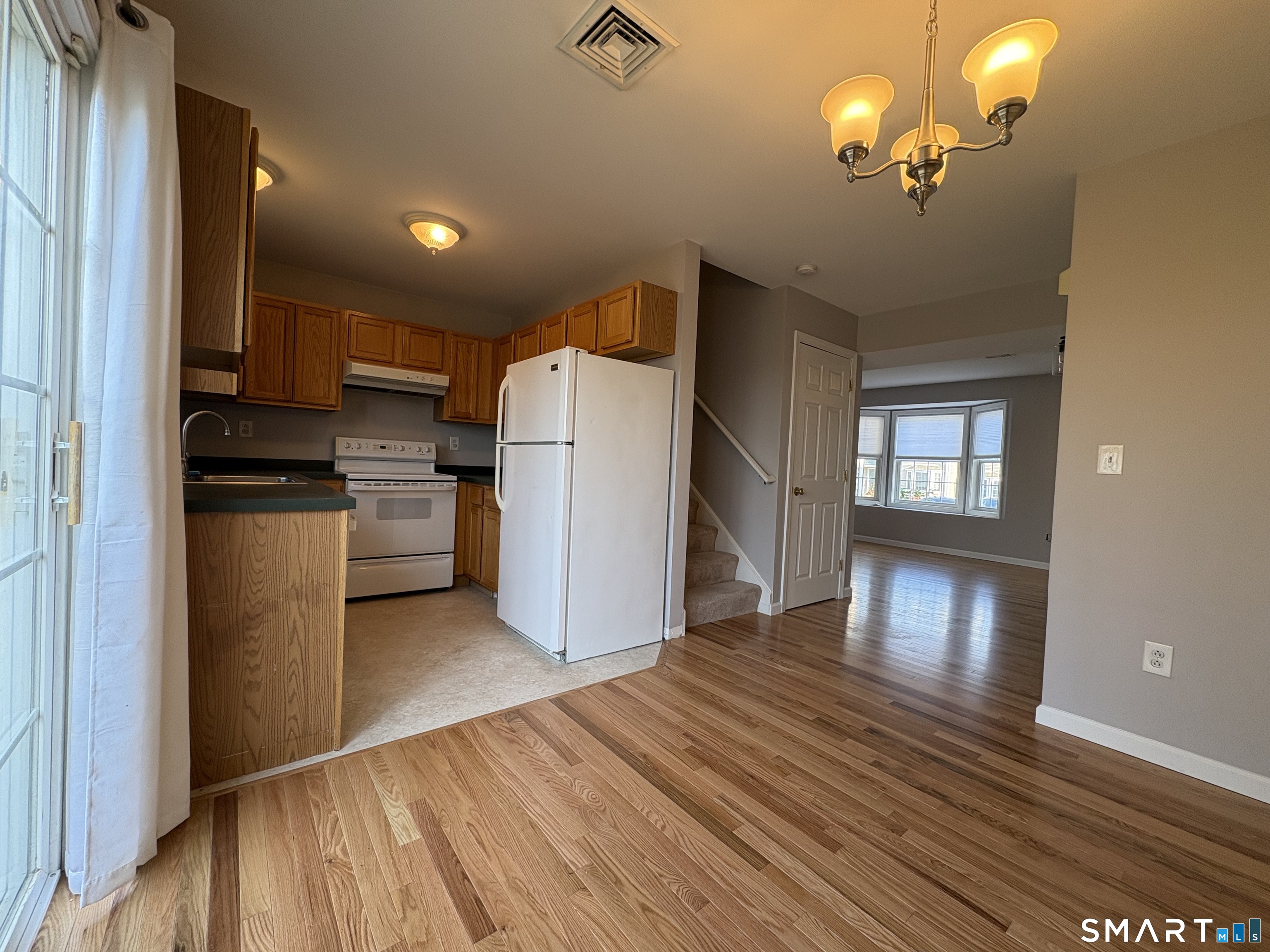 267 Bridge Street, Unit 18 Groton, CT 06340 - Photo 6 of 16 a view of a kitchen with a refrigerator a microwave and a stove top oven