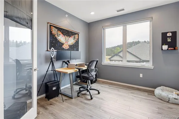 a workspace with wooden floor and a window