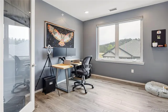 a workspace with wooden floor and a window