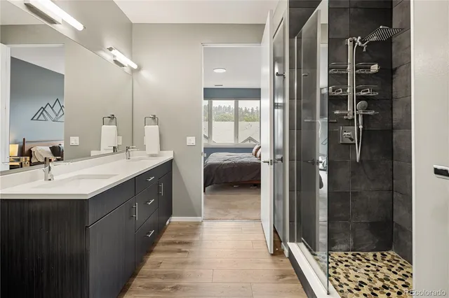 a en suite bathroom with a double vanity sink a mirror and shower