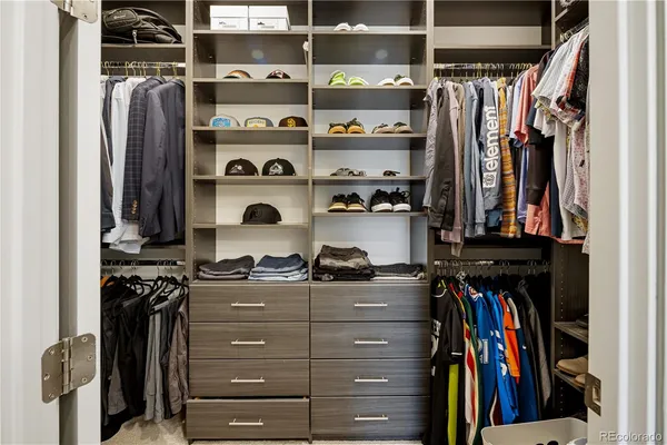 a view of walk in closet with clothes and shoes