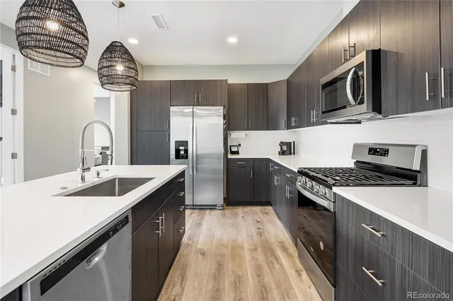 a kitchen with kitchen island granite countertop a sink stainless steel appliances and cabinets
