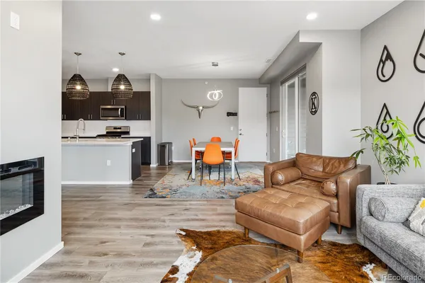 a living room with furniture kitchen view and a fireplace
