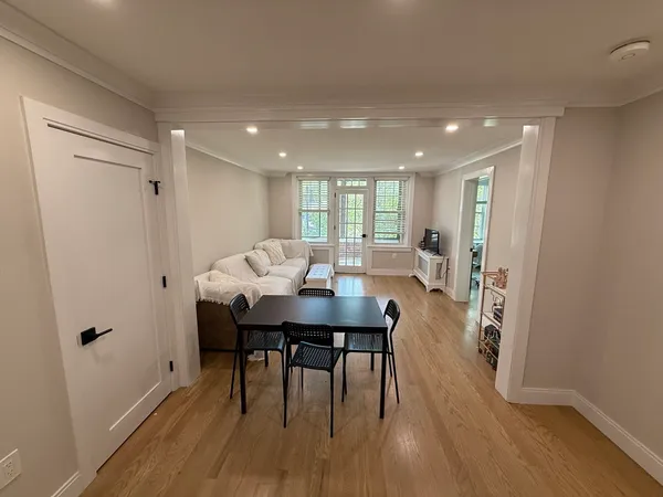 a view of a a dining room with furniture window and wooden floor
