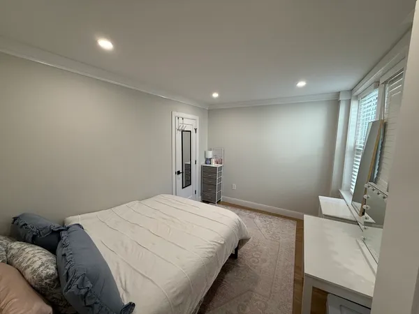 a spacious bedroom with a bed and a flat screen tv