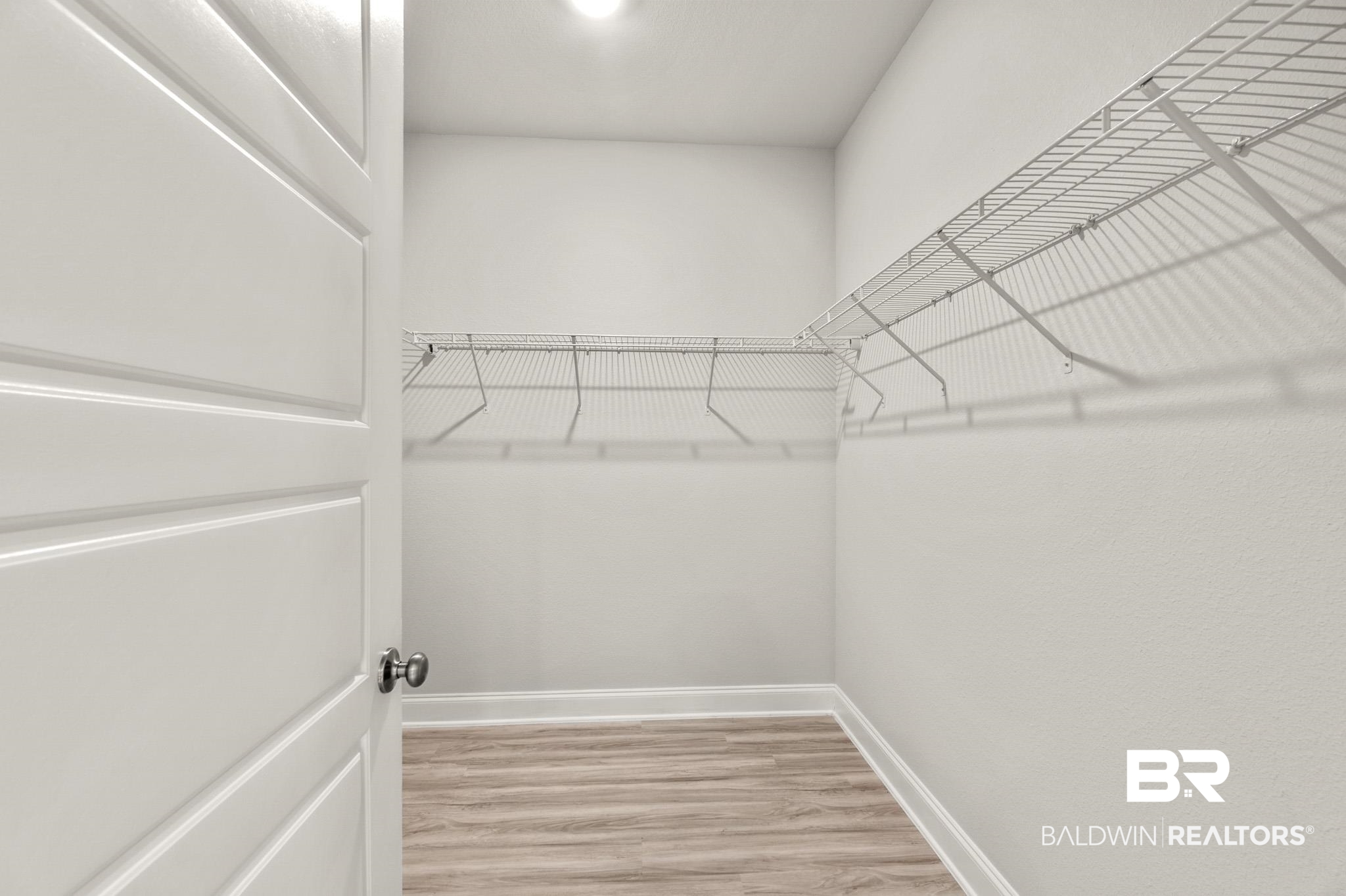 32125 Lyon Road Daphne, AL 36527 - Photo 19 of 70 Walk-in closet with wire shelving system, wood-finish flooring, and crisp white baseboards
