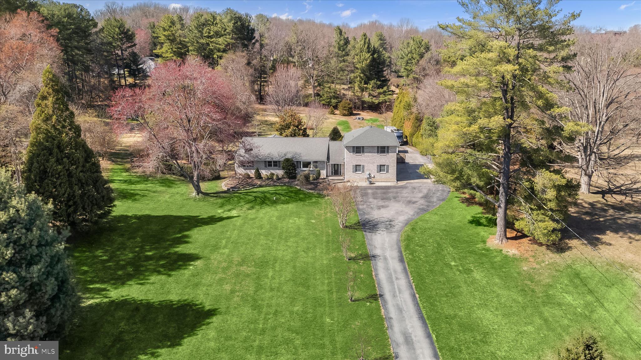 an aerial view of residential houses with outdoor space and trees