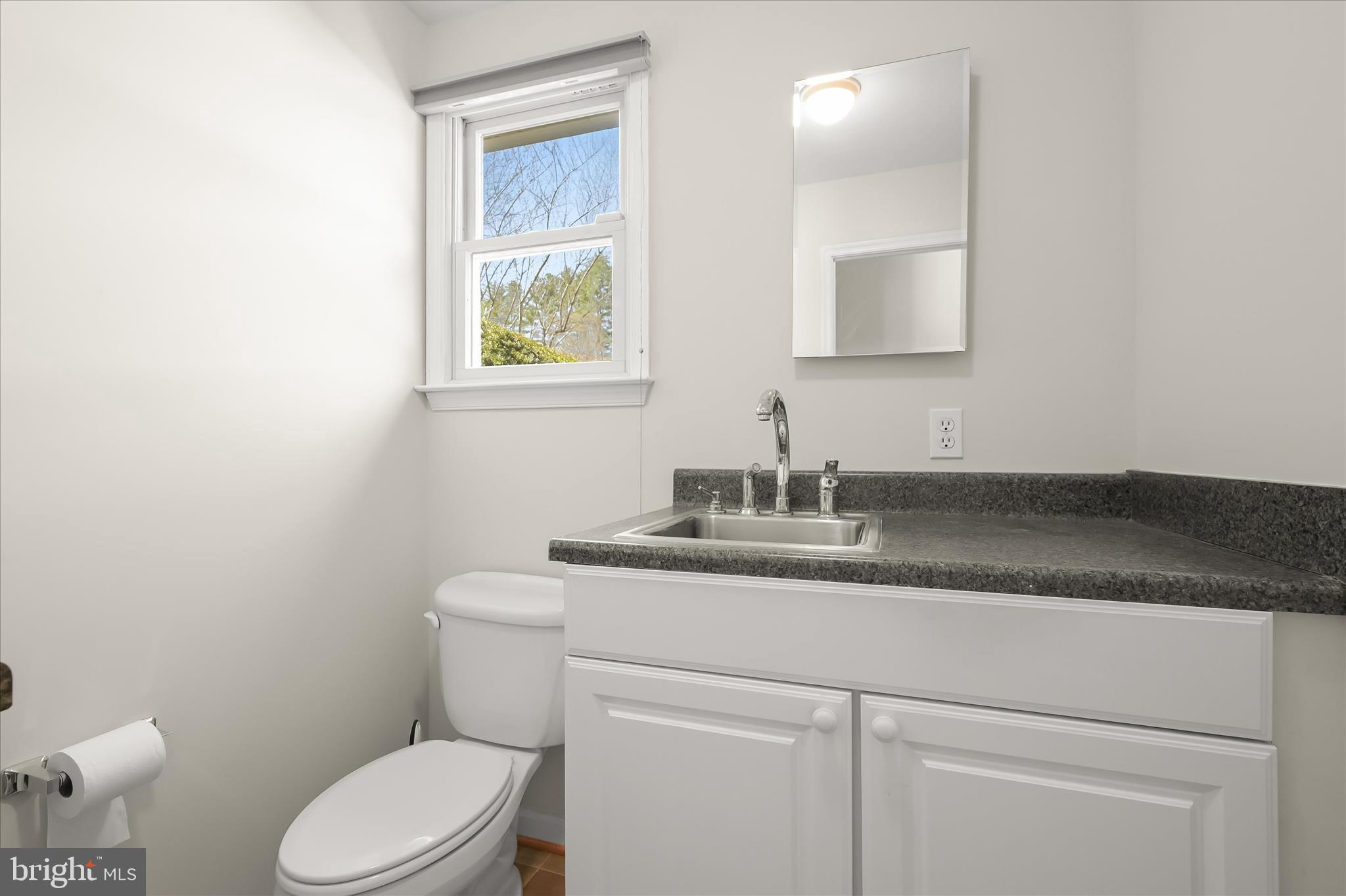 6910 Pindell School Road Clarksville, MD 21029 - Photo 41 of 73 a bathroom with a granite countertop toilet sink and mirror