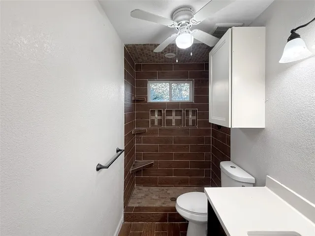 a bathroom with a toilet a sink and mirror
