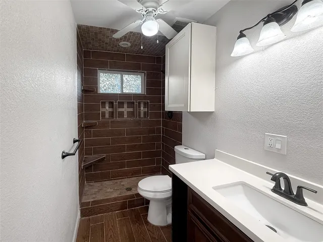 a bathroom with a sink a toilet and shower