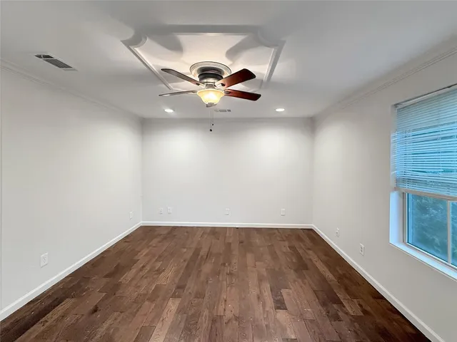 a view of a room with wooden floor and ceiling fan