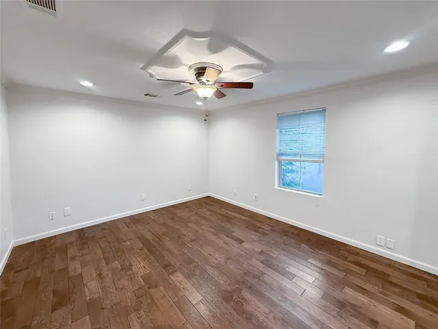 an empty room with windows and fan