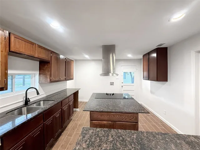 a large kitchen with stainless steel appliances granite countertop a sink and a stove