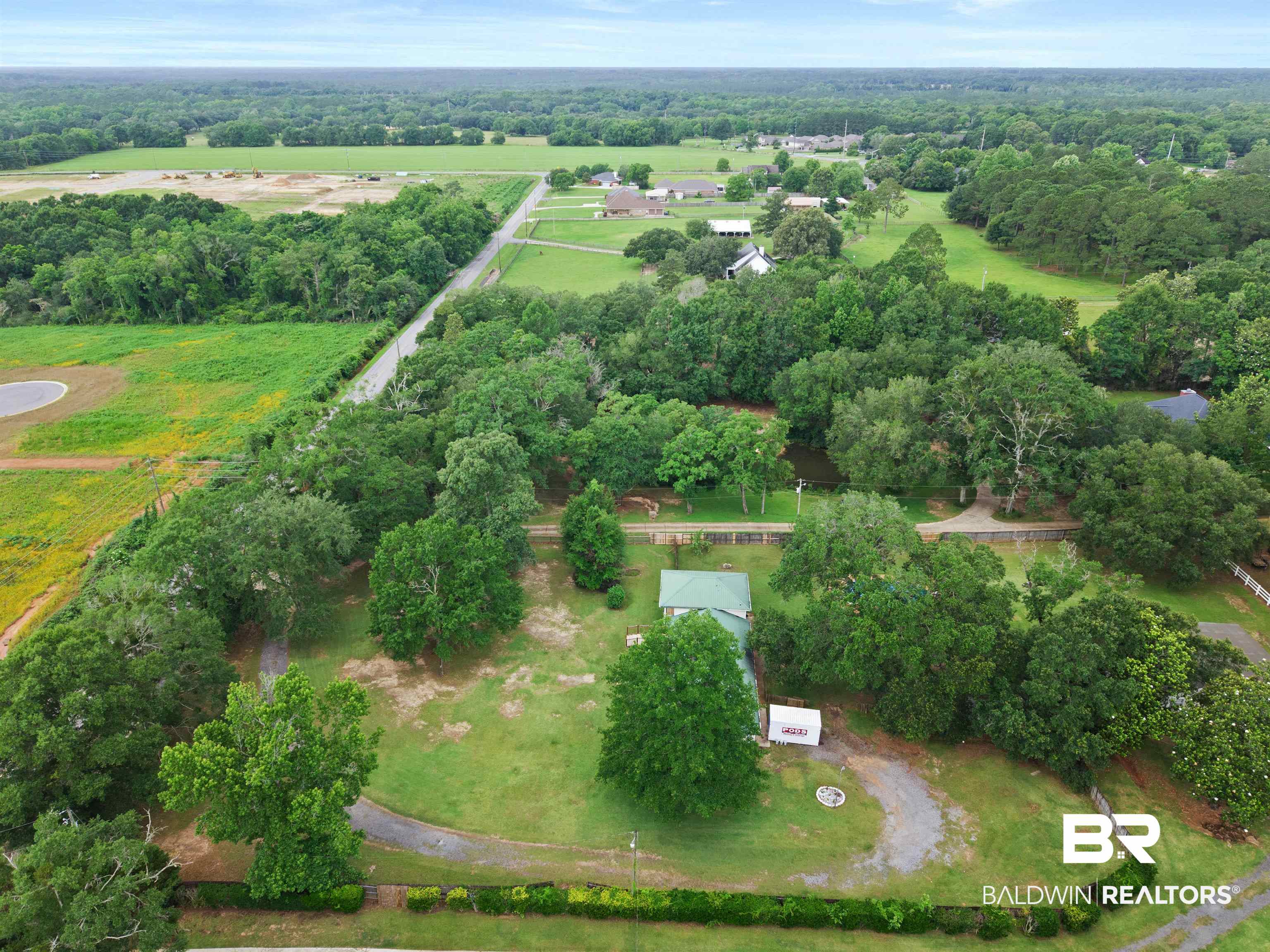 10420 Johnson Road South Mobile, AL 36695 - Photo 68 of 75 Expansive tree-lined property featuring a gravel driveway, lush green landscaping, and mature foliage