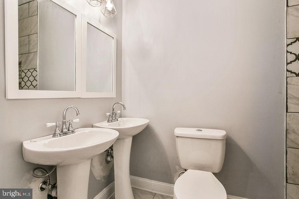 917 North Rose Street Baltimore, MD 21205 - Photo 17 of 34 a bathroom with a toilet a sink and a mirror
