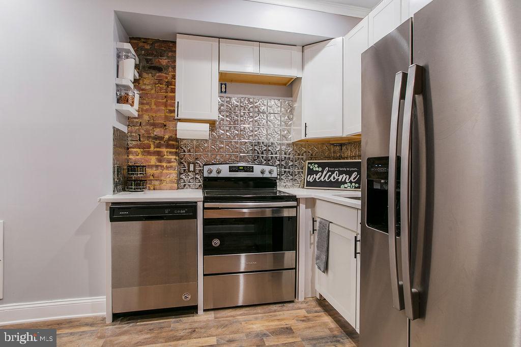 917 North Rose Street Baltimore, MD 21205 - Photo 9 of 34 a kitchen with stainless steel appliances granite countertop a refrigerator and a stove
