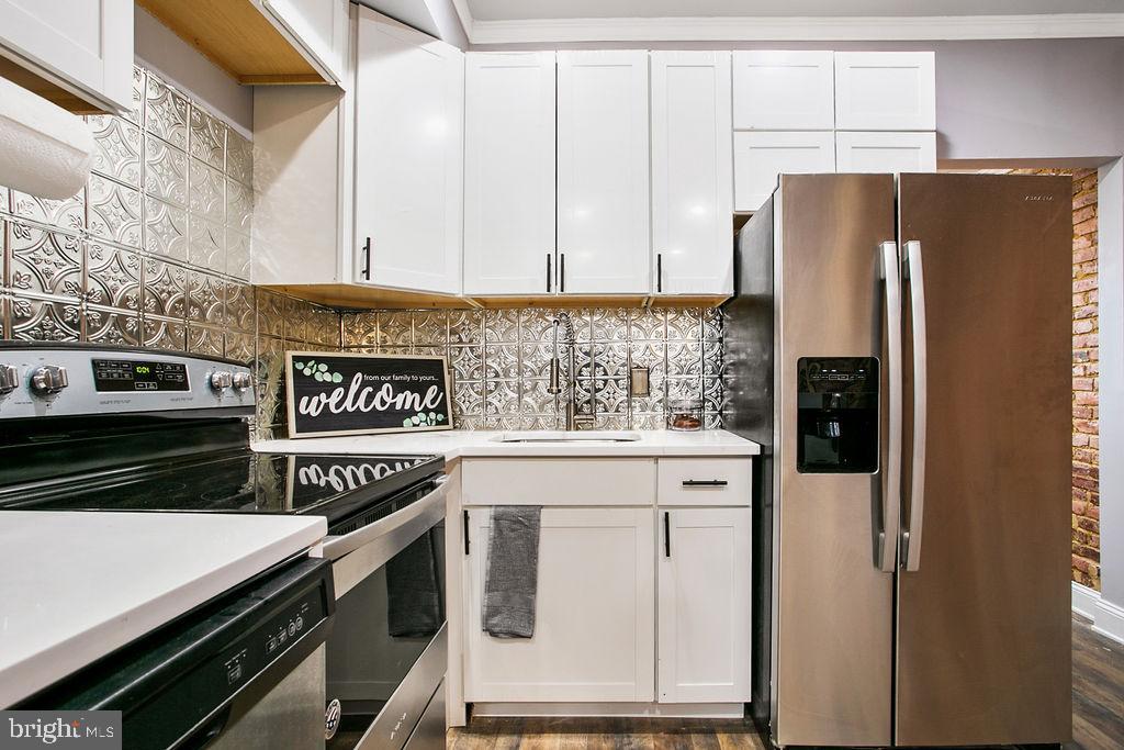 917 North Rose Street Baltimore, MD 21205 - Photo 10 of 34 a kitchen with stainless steel appliances a refrigerator a stove and cabinets