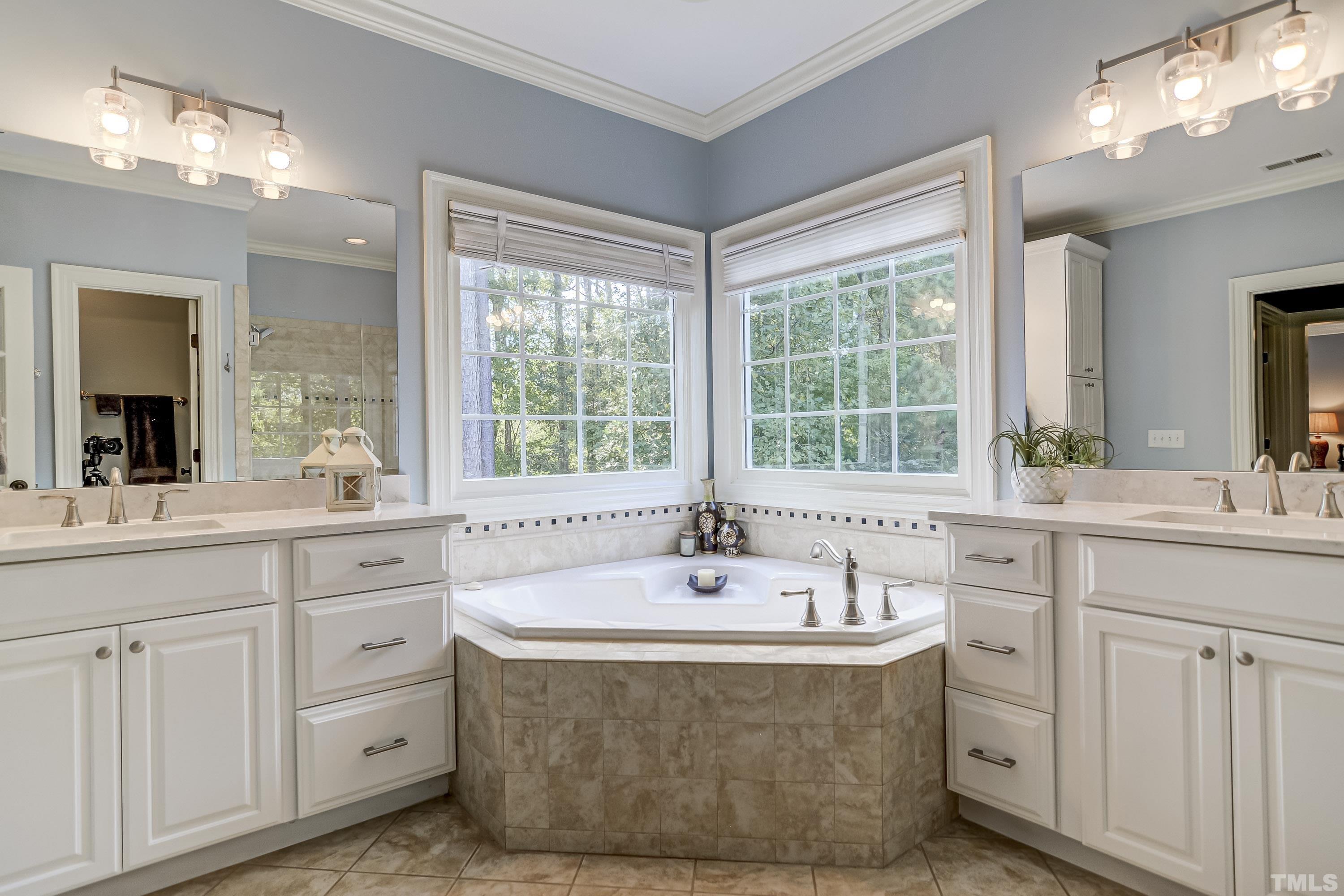 1520 Consett Court Raleigh, NC 27613 - Photo 14 of 30 a spacious bathroom with a double vanity sink a mirror a window and a bathtub