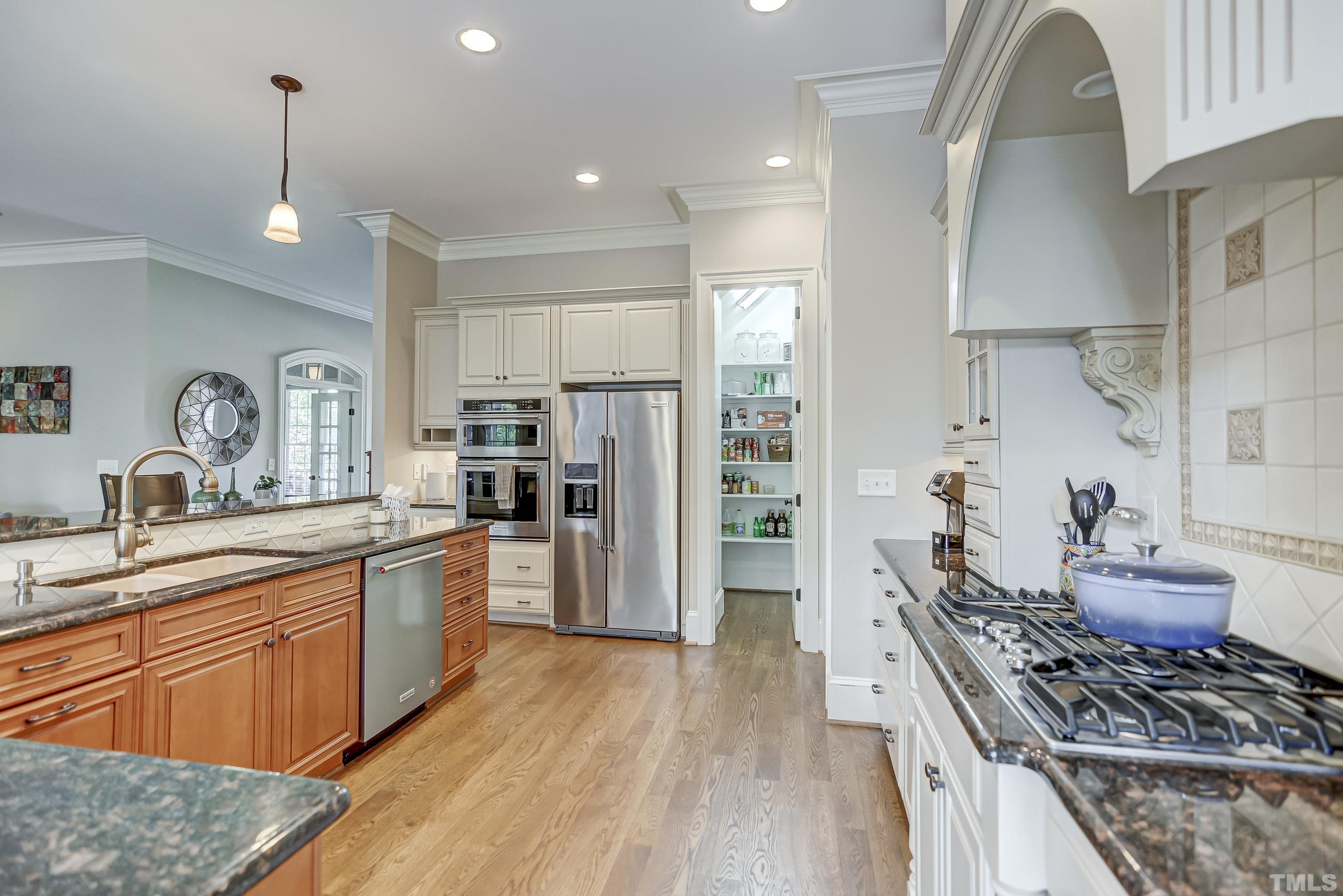 1520 Consett Court Raleigh, NC 27613 - Photo 7 of 30 a kitchen with stainless steel appliances granite countertop a stove refrigerator and cabinets