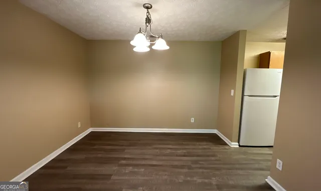 a view of a room with wooden floor and a ceiling fan