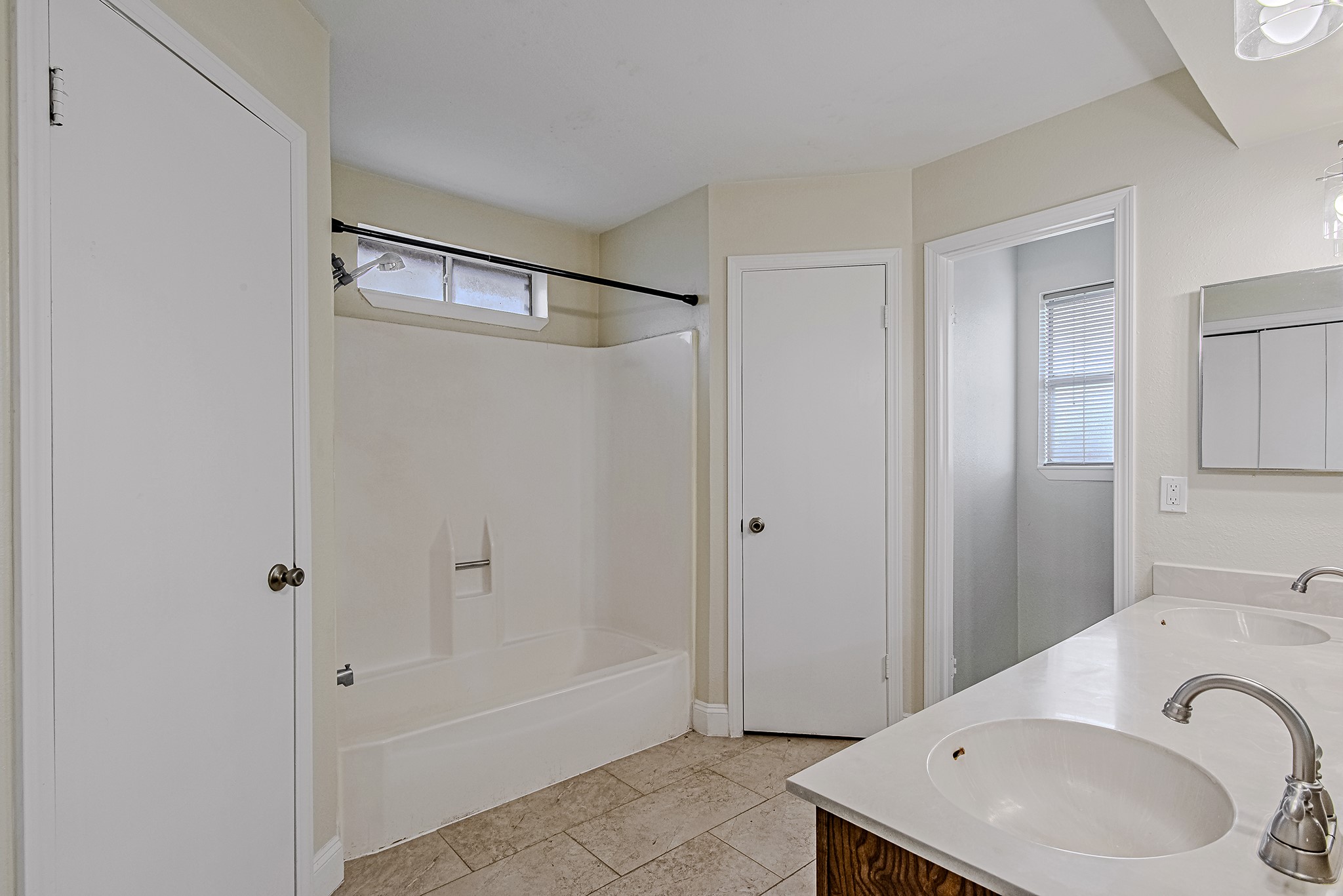17811 Hawk Haven Lane Spring, TX 77379 - Photo 14 of 24 Primary en suite bathroom featuring dual sinks, a tub/shower combination, and separate his-and-hers closets flanking the bathing area for added functionality and storage.