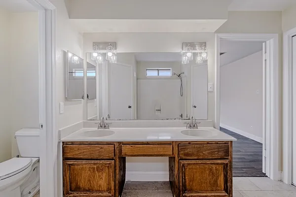a bathroom with a sink a toilet and a mirror