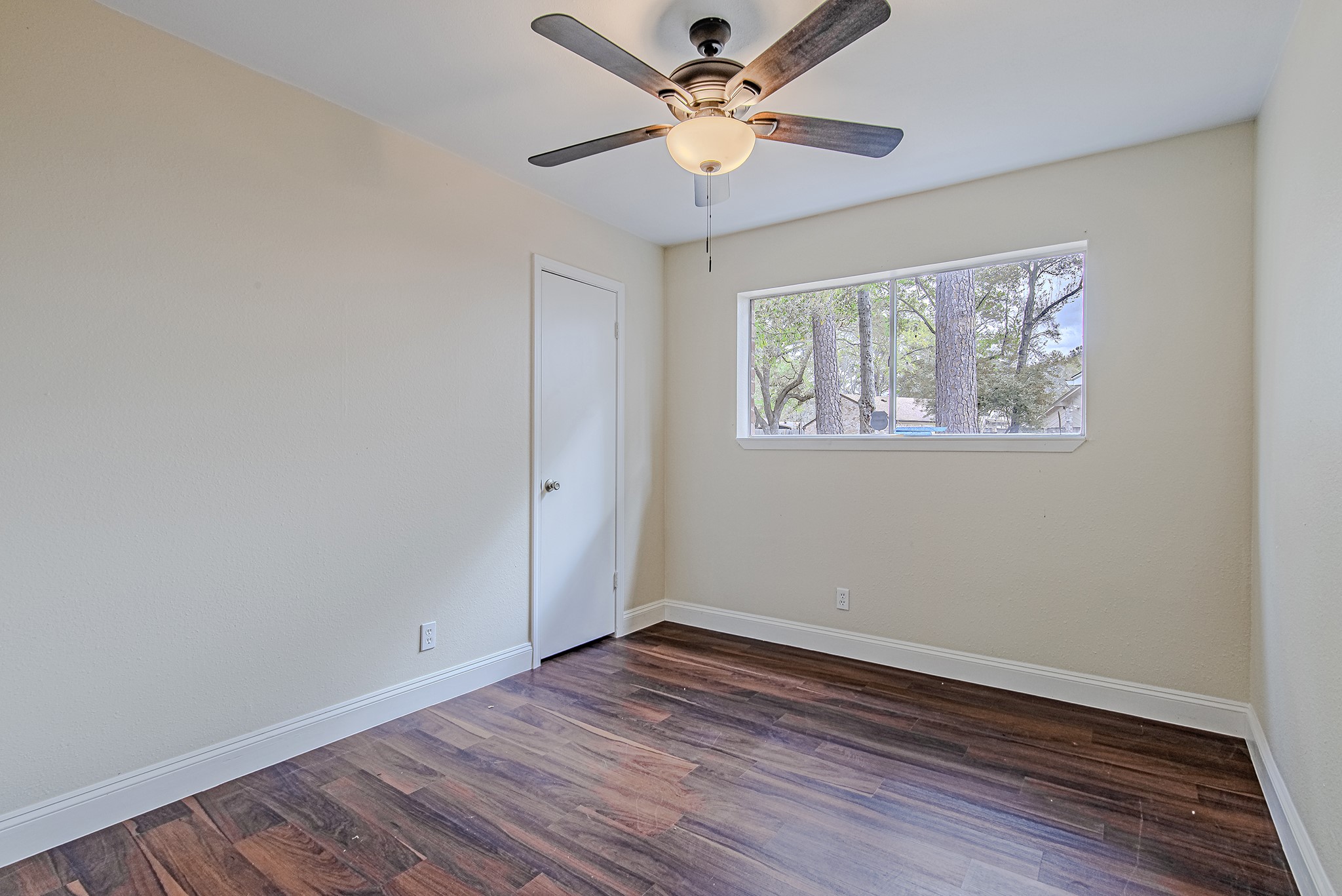 17811 Hawk Haven Lane Spring, TX 77379 - Photo 18 of 24 Secondary bedroom with rich flooring, natural light, and a comfortable layout ideal for family, guests, or a home office. Ceiling fan has been updated since this photo was taken.