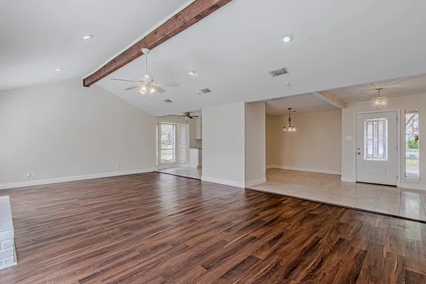 a view of empty room with wooden floor