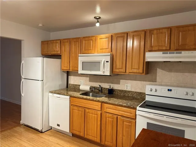 a kitchen with sink a refrigerator and cabinets
